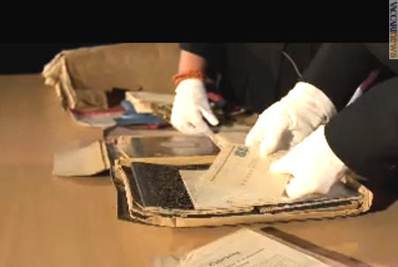 Un fermo immagine del video, in cui la direttrice del Museo Torveig Dahl e il funzionario Kjell Voldheim che esaminano il materiale