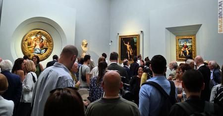 Il pubblico nella sala: tra le opere, il tondo Doni (primo lavoro da sinistra) e la “Madonna del Cardellino” (quarto)