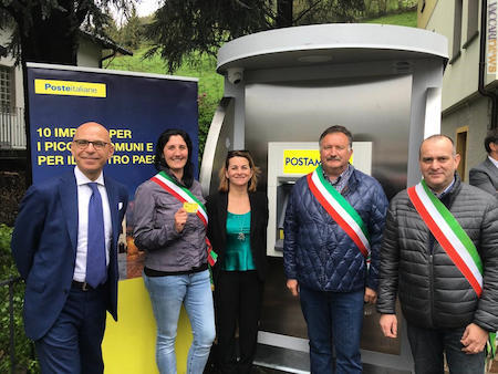 Le comunità locali oggi a Cassiglio (Bergamo) davanti al nuovo postamat. A sinistra, per rappresentare Poste italiane, il responsabile dell’area territoriale Giovanni Accusani 