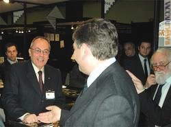 Il ministro alle Comunicazioni, Mario Landolfi (di spalle) mentre visita lo stand di Vaccari srl; lo accoglie Paolo Vaccari. A destra, il collezionista Saverio Imperato